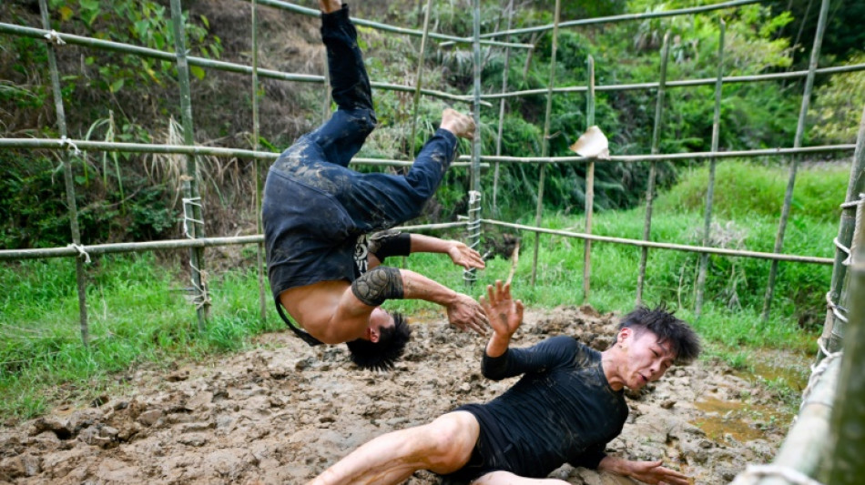 Dans la boue, les catcheurs chinois en qu&ecirc;te de reconnaissance