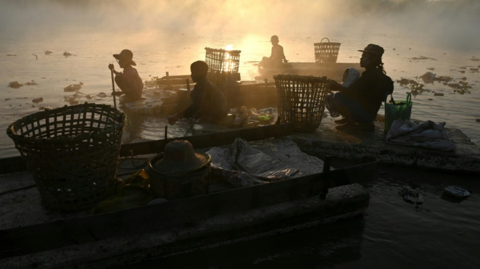 Un equipo de recicladores subsiste recogiendo la basura de un r&iacute;o en Birmania