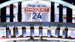 Absent Trump steals show at raucous Republican debate